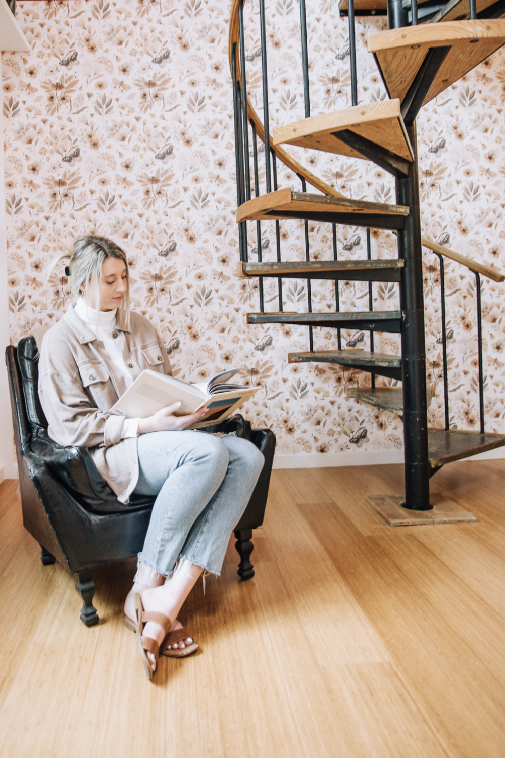woman reading in library with textured wallpaper