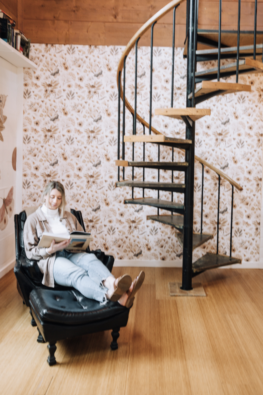 woman reading in study with butterfly wallpaper