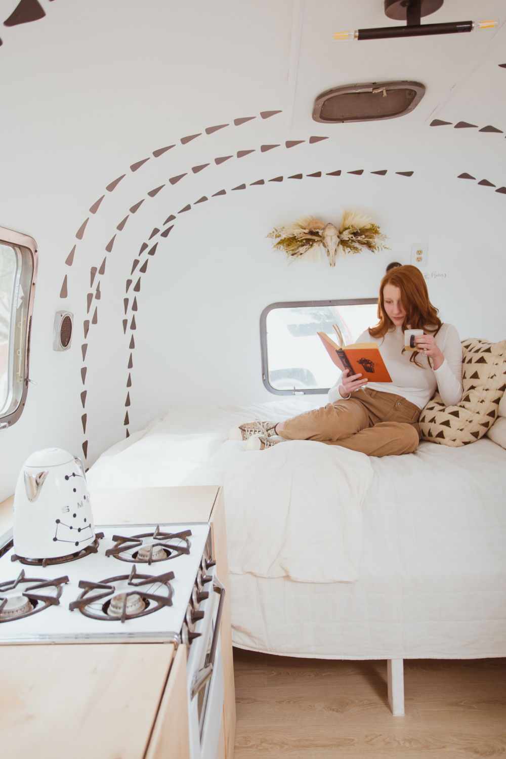 minimalist boho wall decor woman reading in airstream