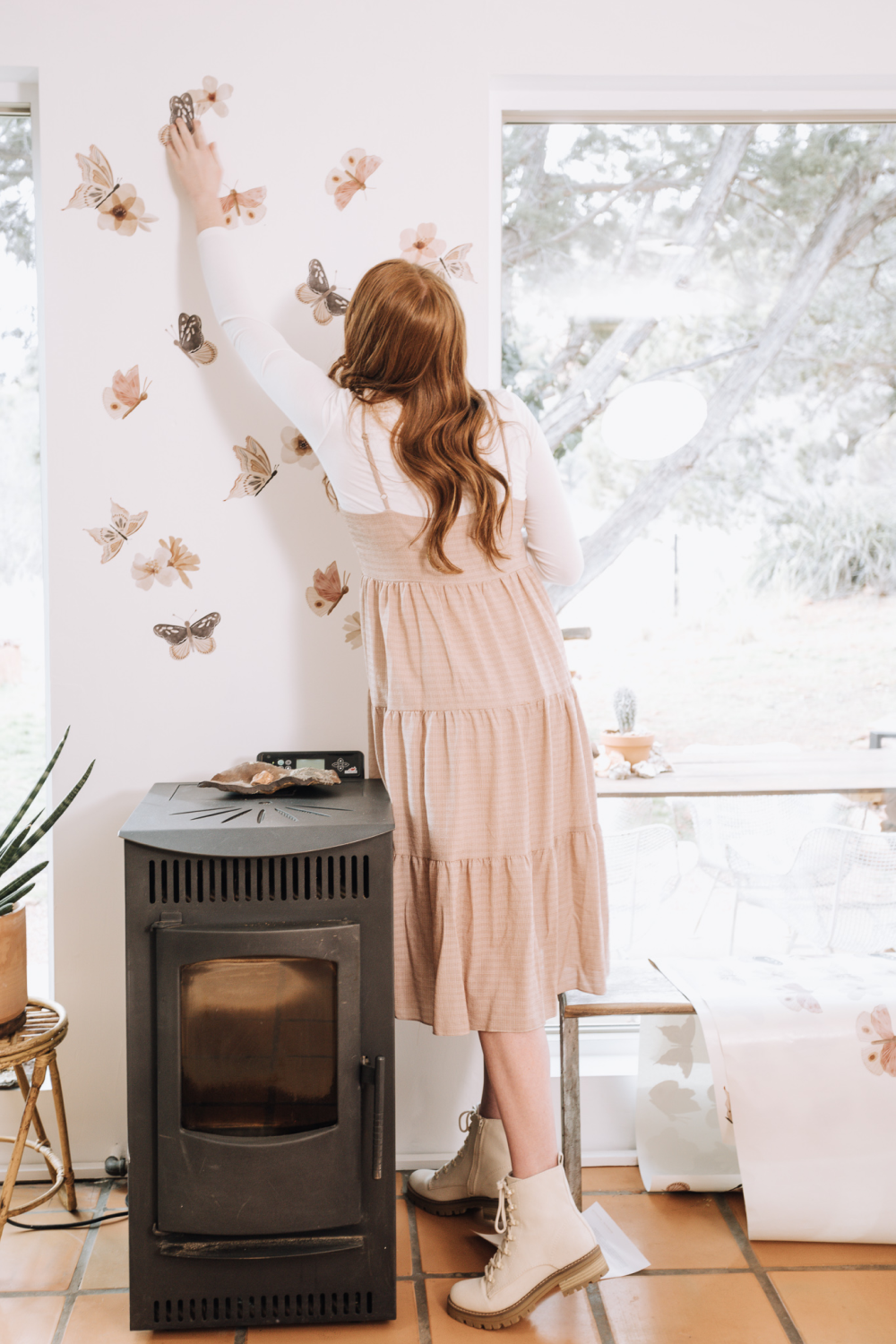 girl installing mini butterfly wall decals from urbanwalls