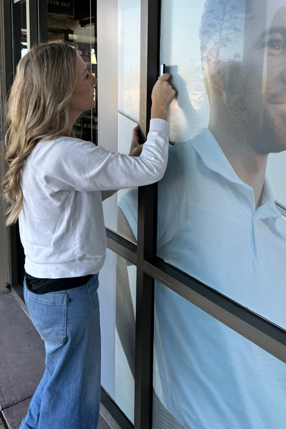 woman installing storefront display from urbanwalls