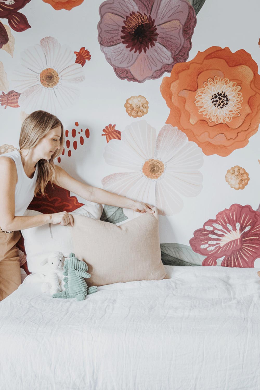 Danielle fixing child's bed in front of Wonderland Wall Decals.