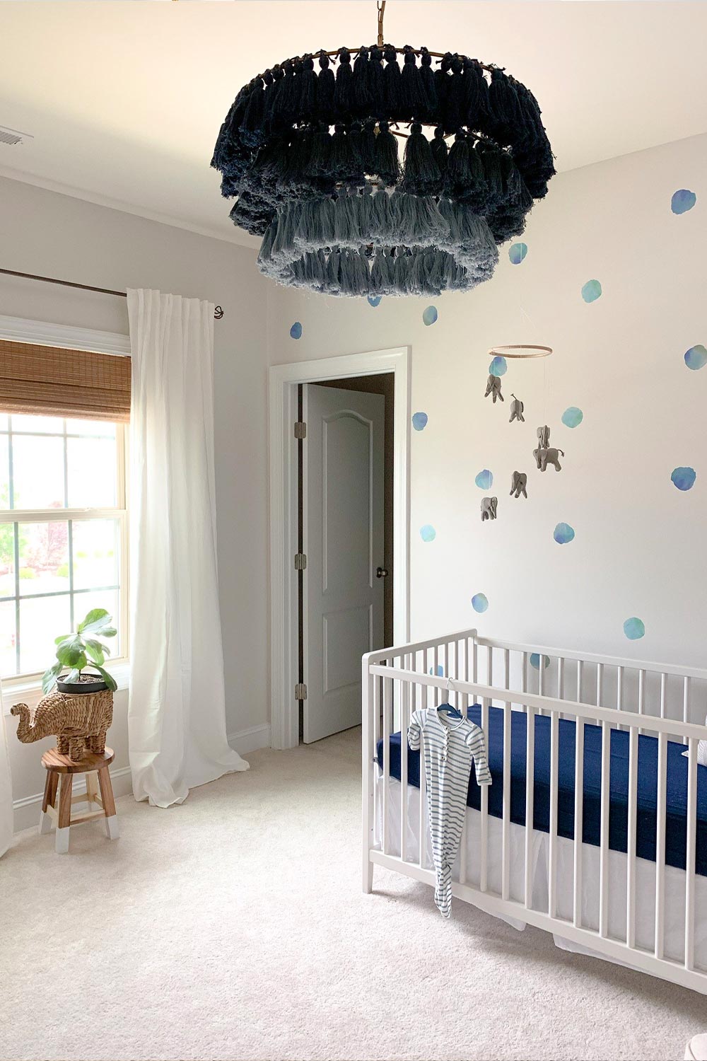 Watercolor Polka Dot Wall Decals, in blue, on a baby boy's nursery wall. With blue and neutral accent pieces.