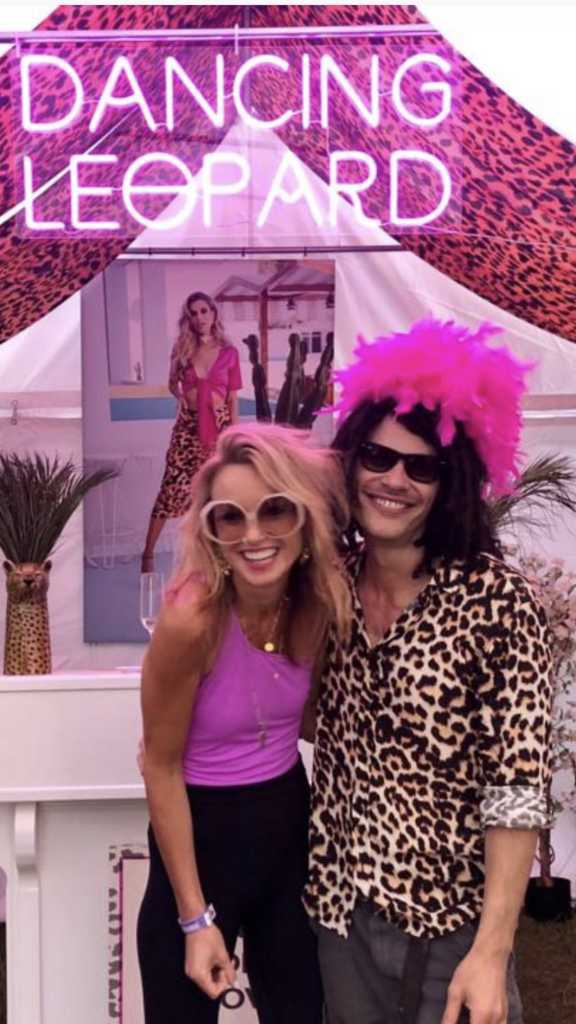 two friends posing for picture in front of Dancing Leopard sign at Boxpark