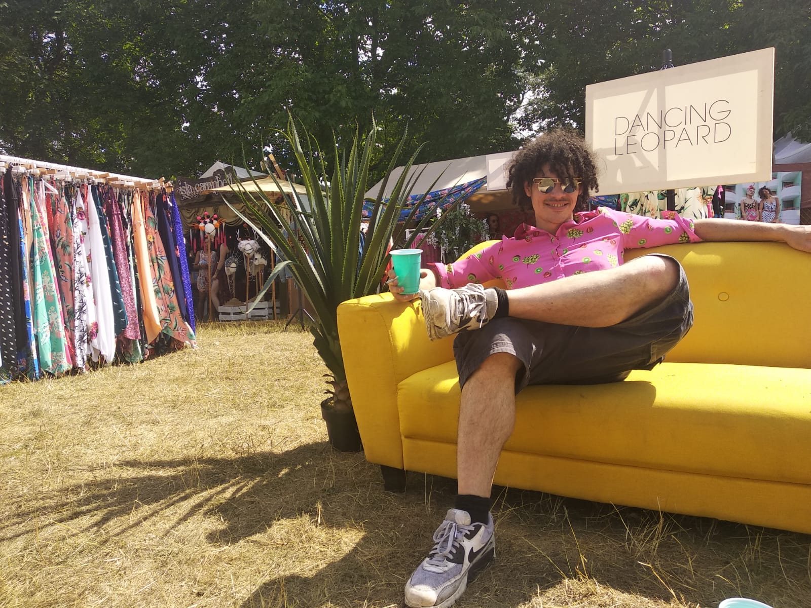 man sat on yellow sofa at Wilderness Festival in front of Dancing Leopard sign