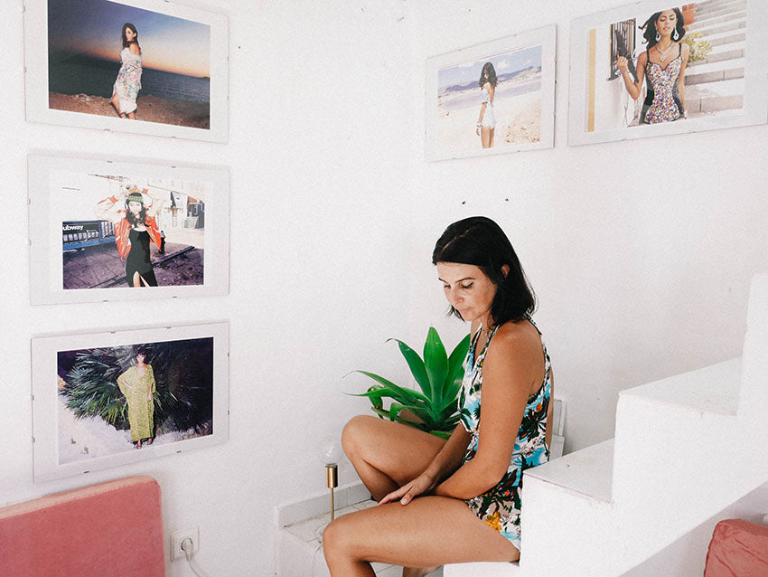 Charlotte sat on stairs with model pictures framed on the wall