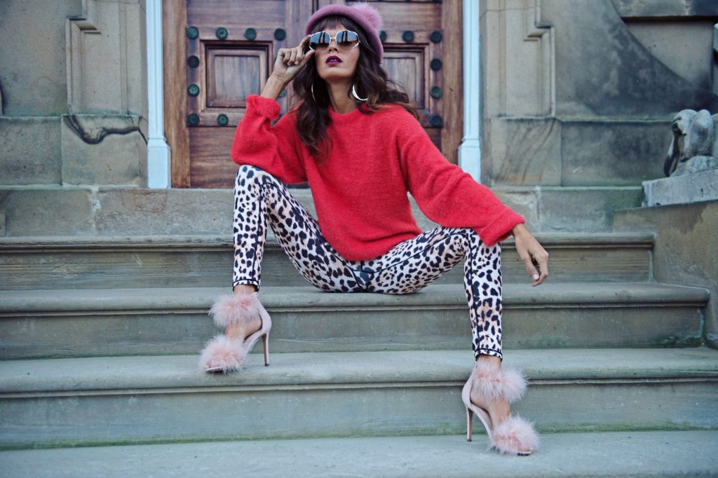 Dancing Leopard model sat on steps peering through sunglasses