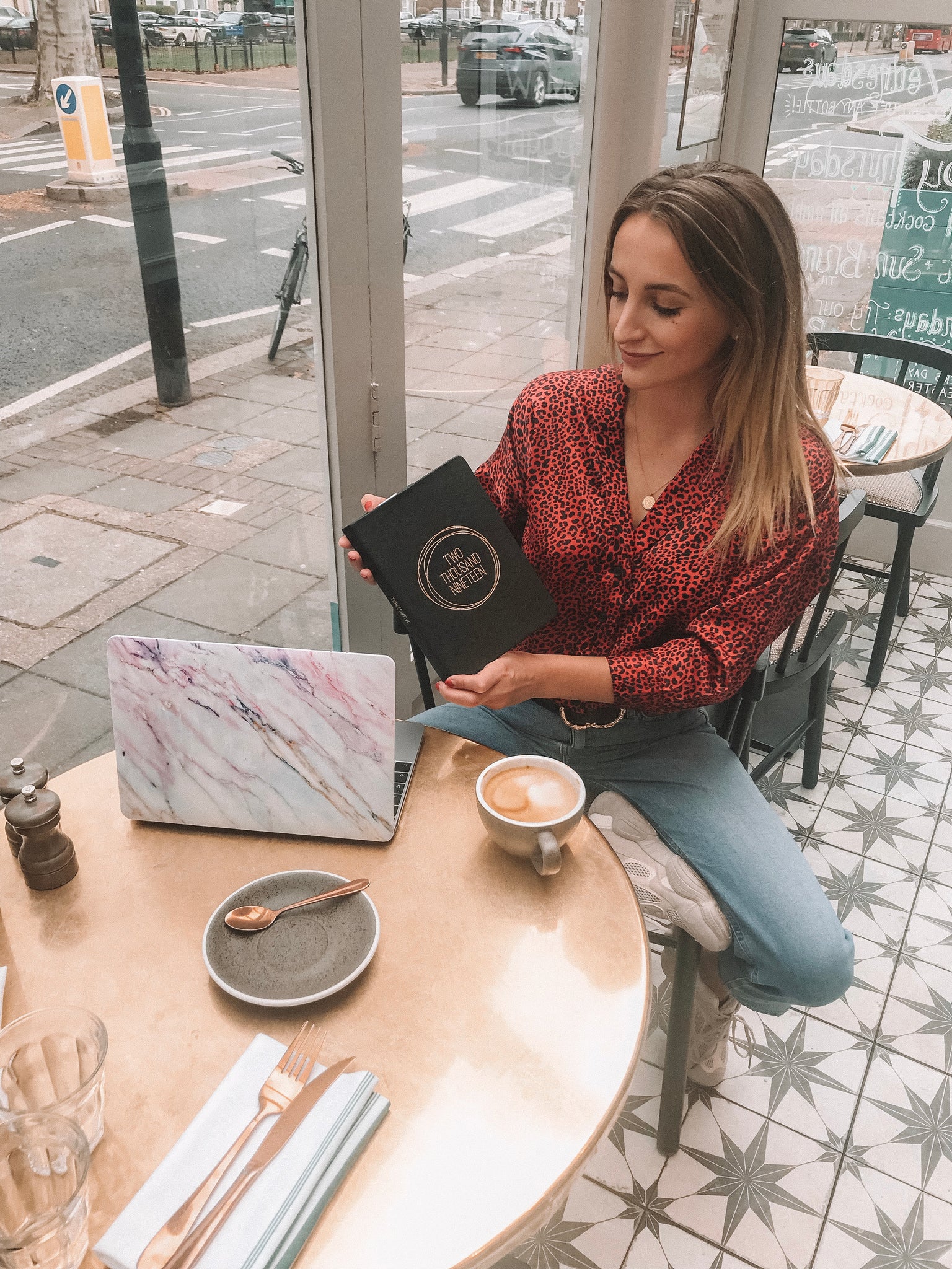 Tiffany Watson in a cafe with laptop, tea and 2019 diary