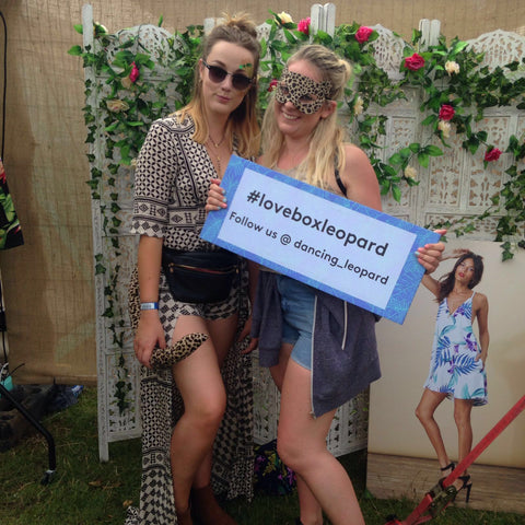 two girls holding #loveboxleopard sign at Lovebox