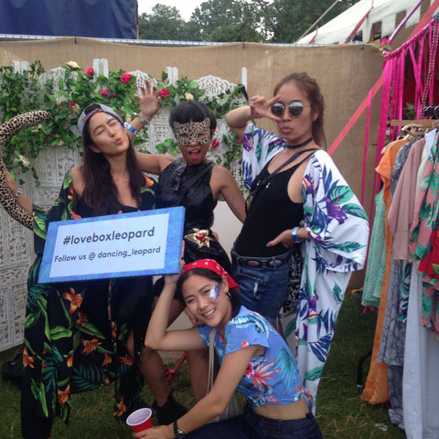 group of friends holding #loveboxleopard sign at Lovebox