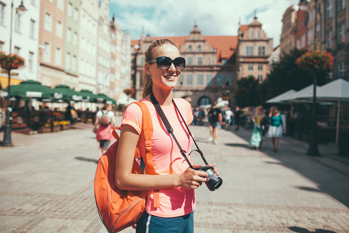 lady holding camera and backpack in Stockholm