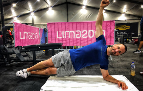 Middle-aged man doing a side plank in a gym wearing Brubeck 3D Pro short sleeve