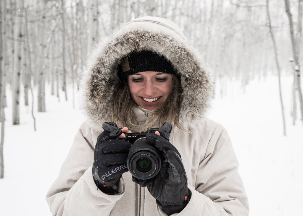 donna sorridente e guardando lo schermo della fotocamera