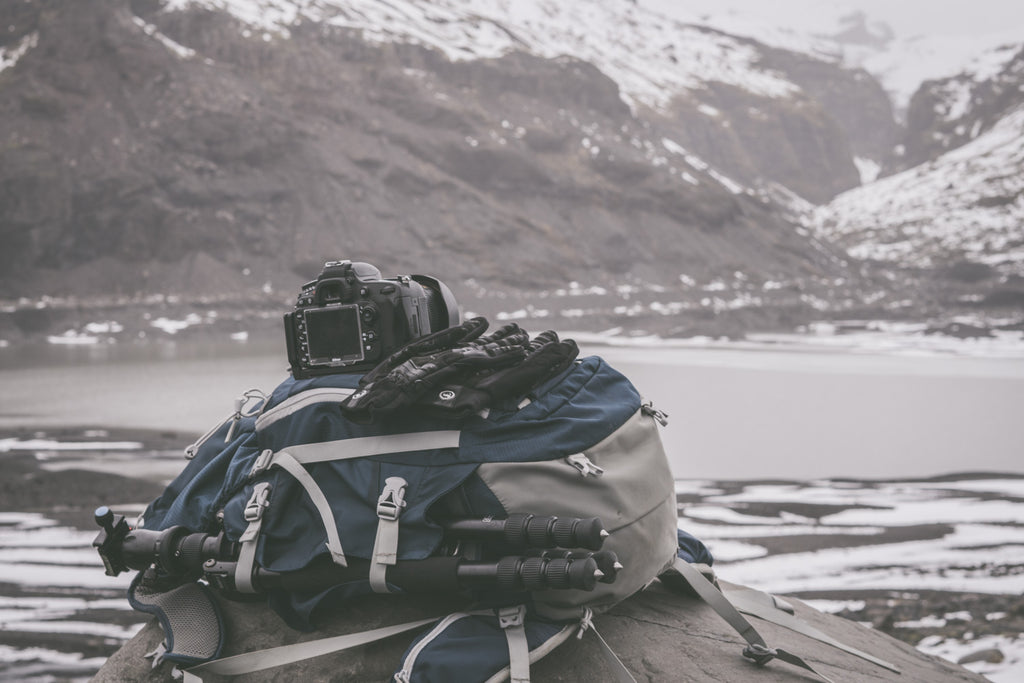 winter photography gear piled up on iceland beach