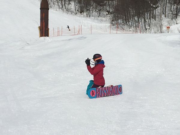 Chica de snowboard tomando una foto