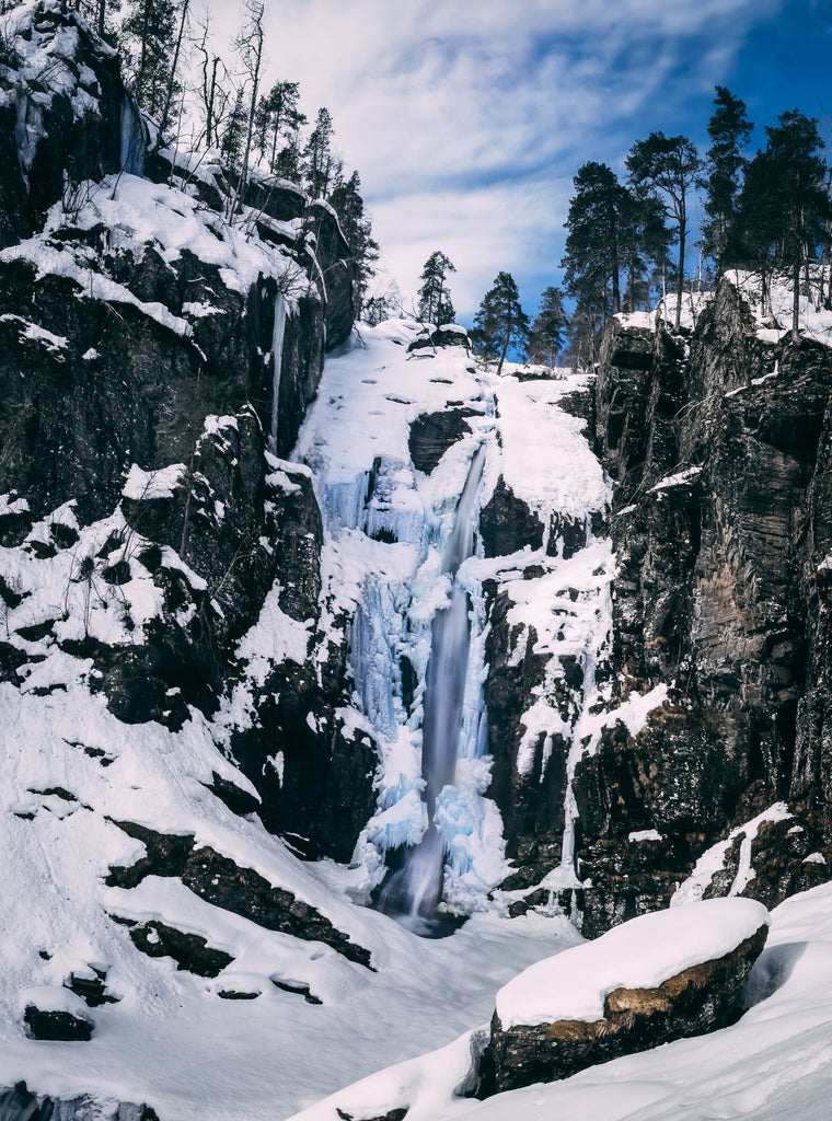 Vertikales Panorama Endbild eines Wasserfalls im Winter