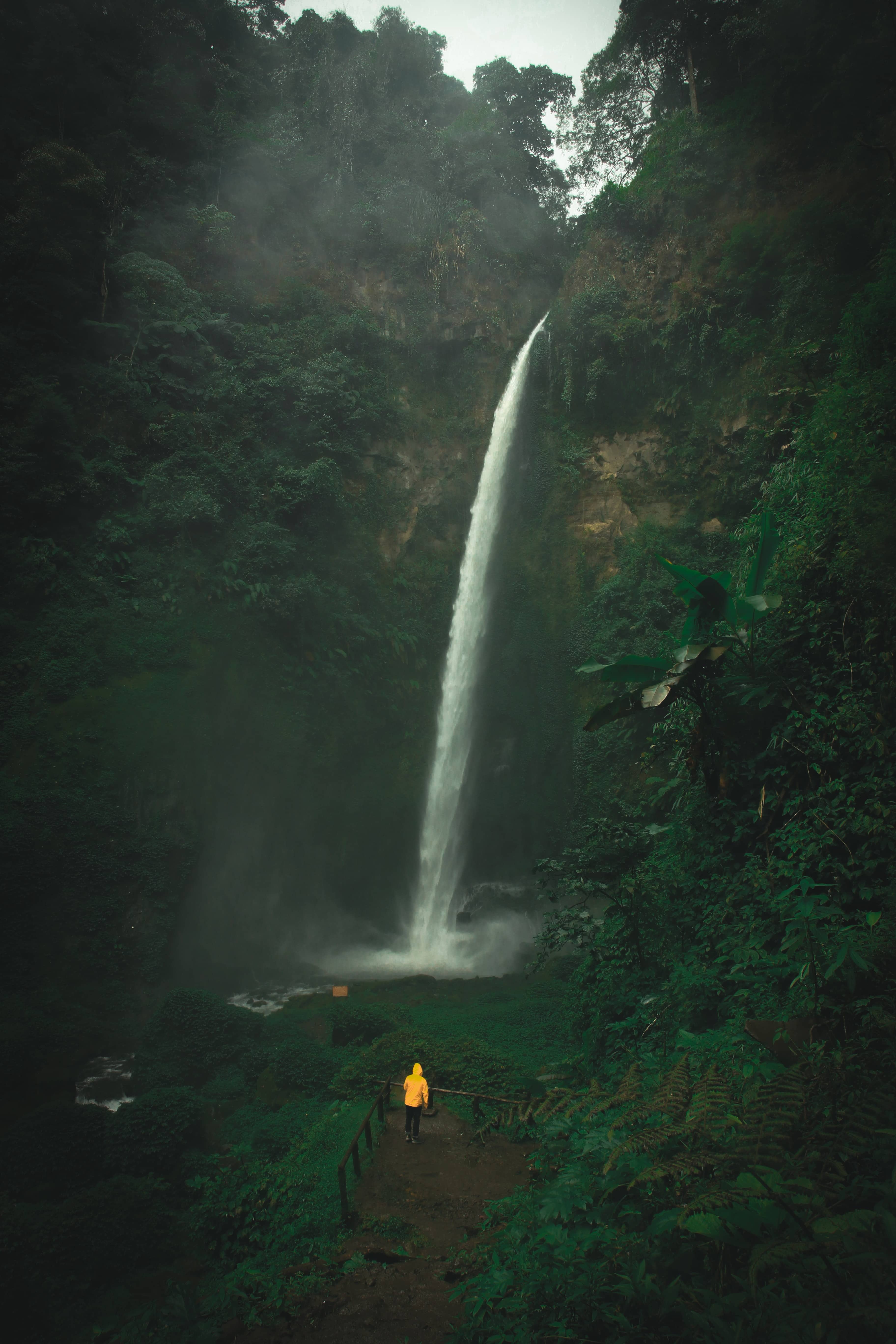 person walking under a water fall in a rainstorm