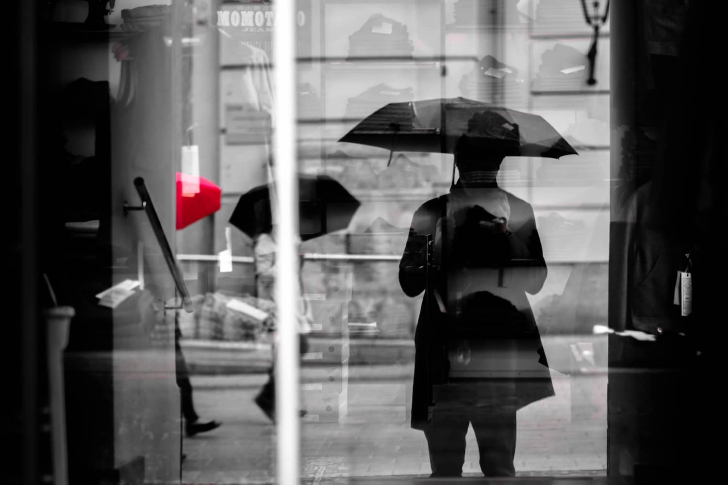 Schwarzweißfoto der Person im Regen mit Regenschirm