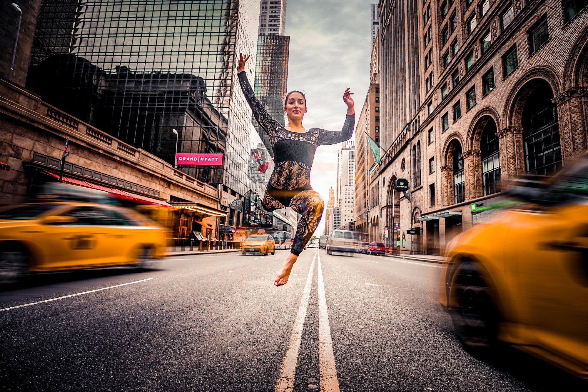 woman jumping in the middle of a busy street