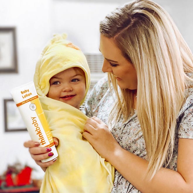 Baby Lotion and Baby in Towel