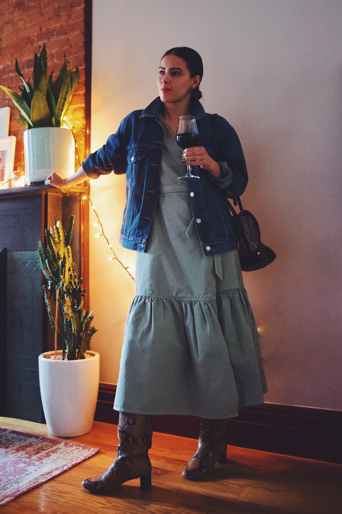 girl wearing ruffle dress with denim jacket and drinking wine