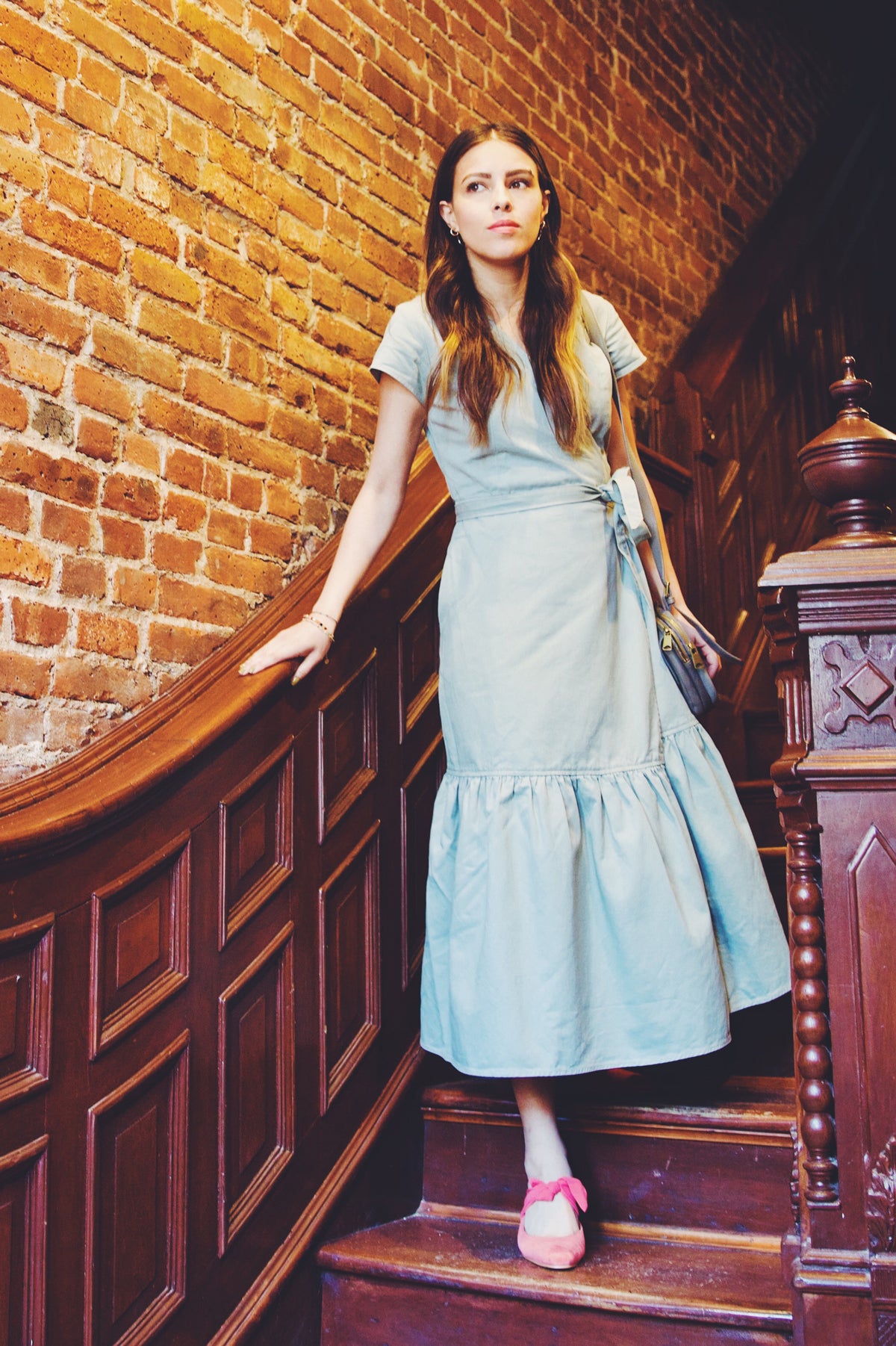 girl walking down stairs in light green denim wrap dress