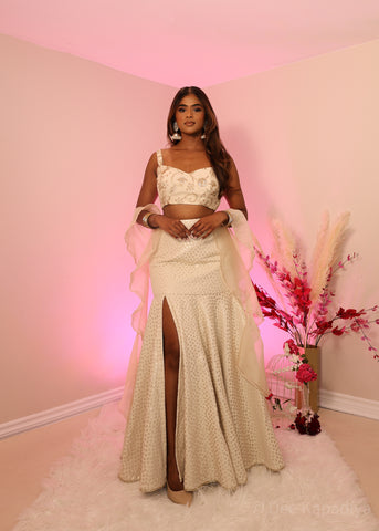 Ecru colour organza croptop with bronze embellishments, paired with champagne coloured polka dot mermaid style lehenga and organza ruffle shawl dupatta, perfect for bridal shower, wedding guest outfit or pre-wedding events