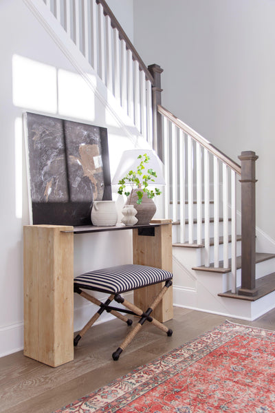 Entryway staircase design with modern rustic console table, custom painting, striped x bench by interior design consultant Kevin Francis in Atlanta