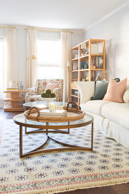 Classic living room design in Atlanta with Oka Avitus linen cloud sofa, brass coffee tables, velvet pillows, and floral rug on design blog The Francis Files by Kevin Francis O'Gara