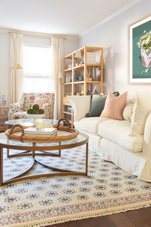 Classic living room design in Atlanta with Oka Avitus linen cloud sofa, brass coffee tables, velvet pillows, and floral rug on design blog The Francis Files by Kevin Francis O'Gara