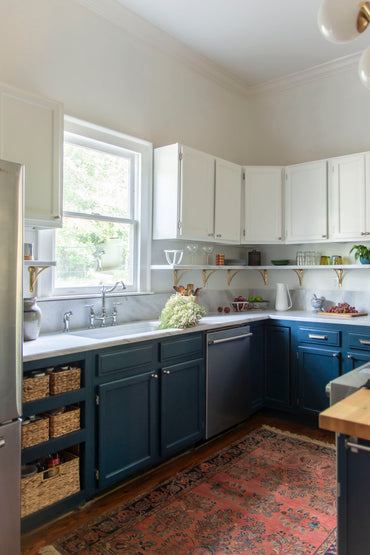Historic kitchen renovation with navy blue cabinets, Georgia marble countertops, fireclay sink, bridge sink faucet, mixed metals, brass and nickel, and Alabaster paint by Kevin Francis Design