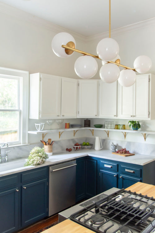 Historic kitchen renovation with navy blue cabinets, Georgia marble countertops, fireclay sink, bridge sink faucet, mixed metals, brass and nickel, and Alabaster paint by Kevin Francis Design