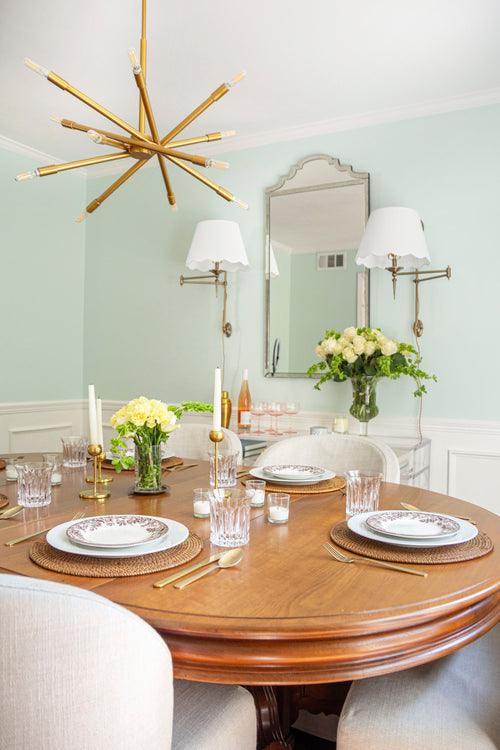 Modern classic dining room with gold chandelier, antique dining table, linen slipcover chairs, plug-in sconces, and Sherwin Williams Green Trance paint with chair rail wainscotting by Atlanta interior designer Kevin Francis O'Gara