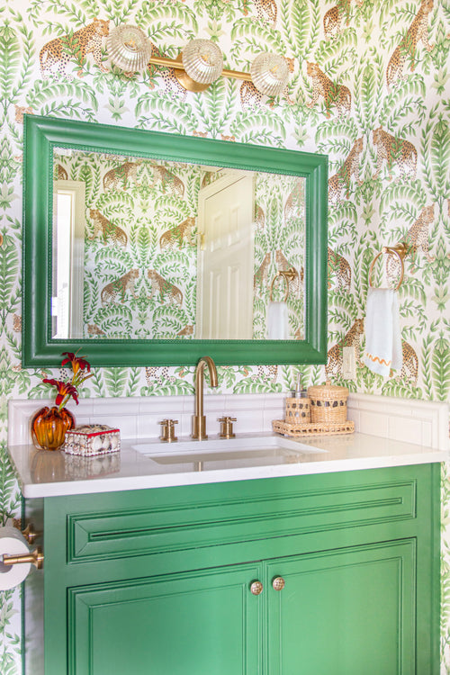 Tropical leopard wallpaper in a bathroom design by Kevin Francis Design, Sherwin Williams Arugula paint on cabinets, green bathroom decor, Atlanta interior designer