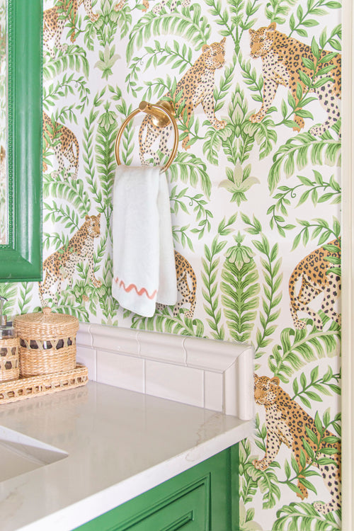Tropical leopard wallpaper in a bathroom design by Kevin Francis Design, Sherwin Williams Arugula paint on cabinets, green bathroom decor, Atlanta interior designer