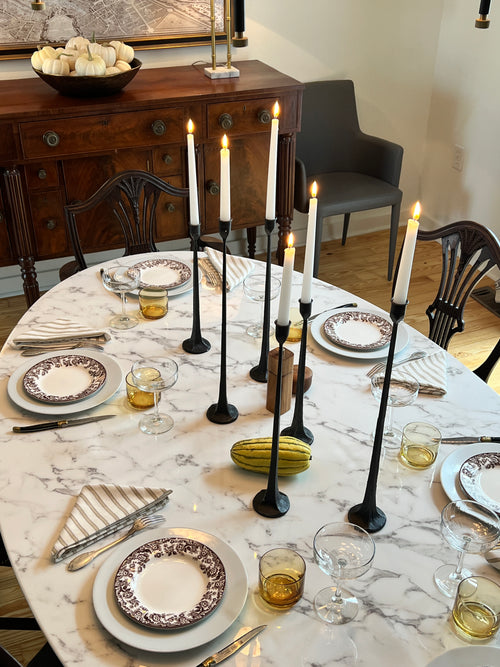 Moody, simple fall table setting with iron candleholders, Spode plates, striped napkins, and yellow glassware by Atlanta designer Kevin Francis O'Gara