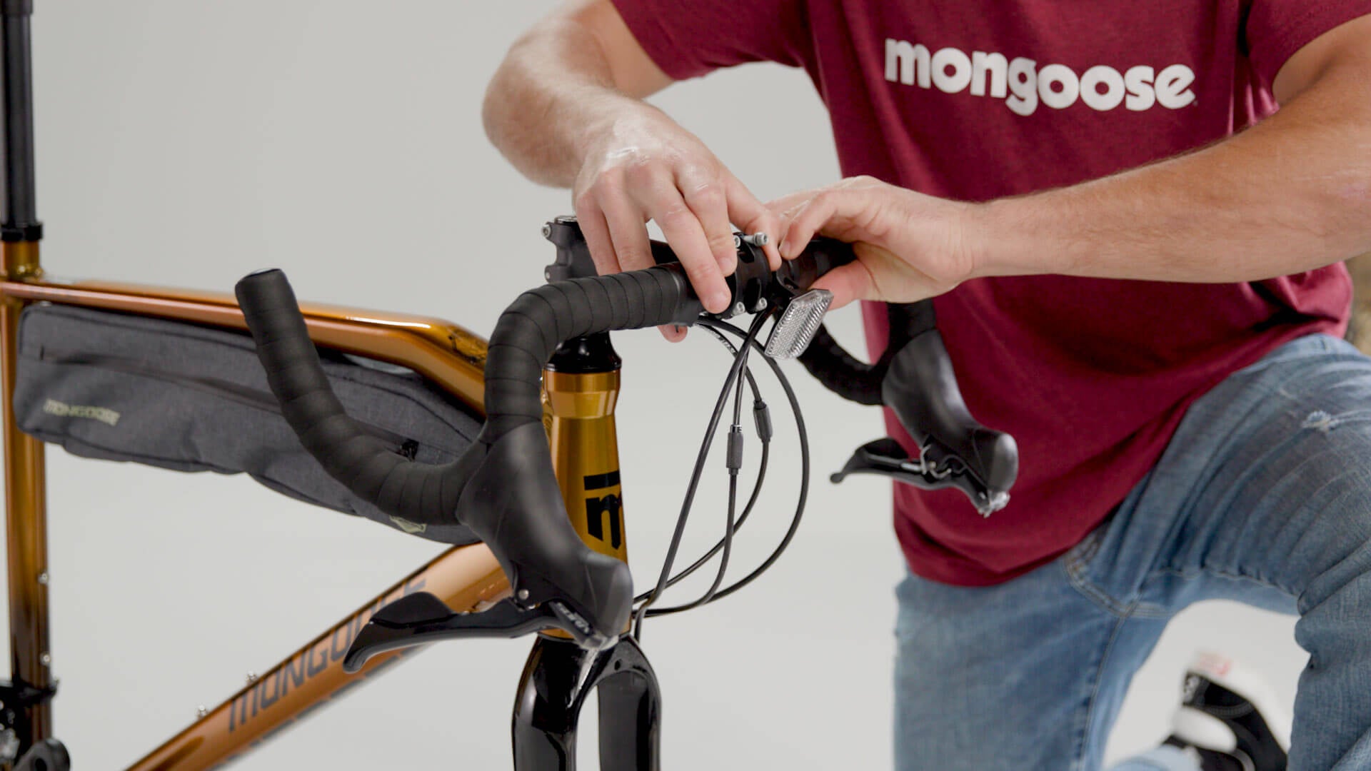 A person installing the handlebars on a Mongoose Guide adventure bike.