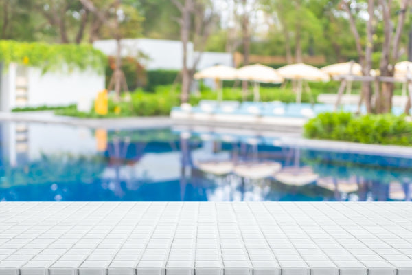 Close Up of White Pool Tile with Blurred Pool Background