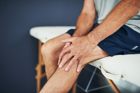 Man with Arthritis in the knee holding his knees in pain 