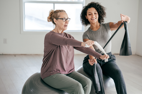 Woman with arthritis doing gentle exercises with her instructor. 