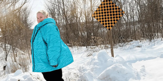 A woman wearing a plus size winter jacket standing in the snow