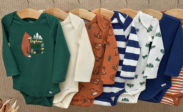 Fall-themed baby boy bodysuits, lovingly arranged on wooden hangers for easy selection.