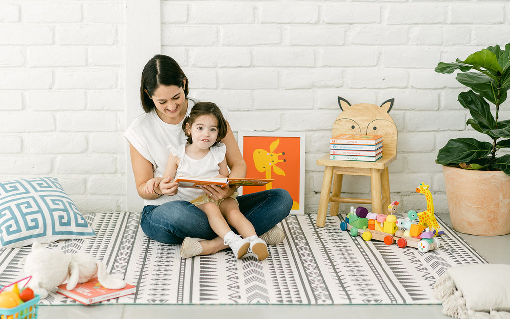 mother reads to child sitting on her lap in nursery