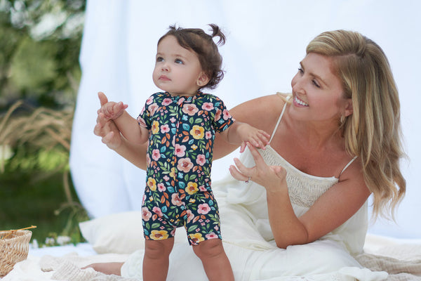 Mom with daughter wearing floral romper outside