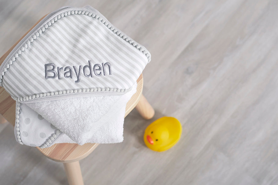 gray and white bath towel embroidered with name "Brayden"