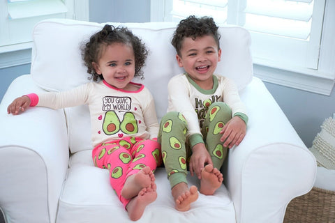 two toddlers sitting in chair together smiling