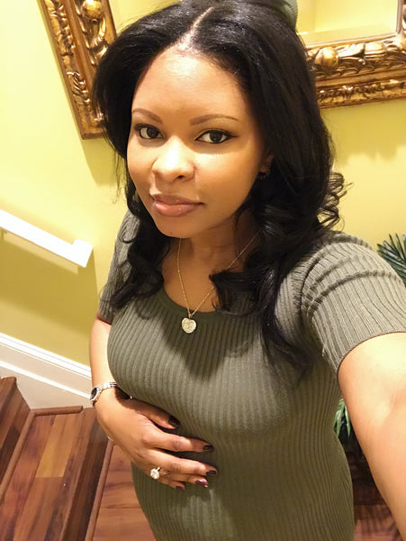 Monique poses with hand over pregnant belly