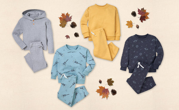 Snuggle up in style! Check out these cute toddler boy outfits, consisting of pajamas and a hoodie, beautifully arranged on a flat surface with autumn leaves adding a touch of nature's charm.