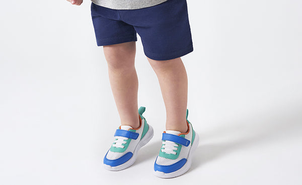 toddler boy in bright color block shoes