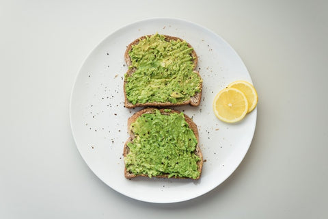 toasted bread with avocado spread and lemon garnish